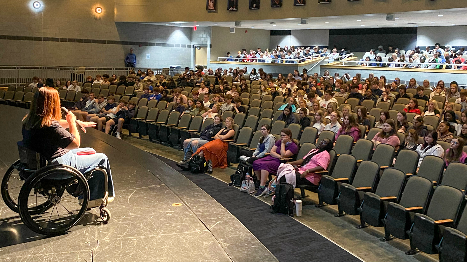 man in wheel chair talking to students